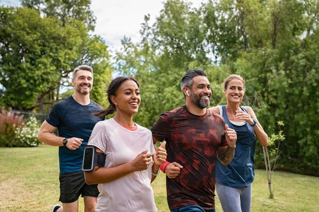 Healthy group of multiethnic middle aged men and women jogging at park. Happy mixed race couples running together. Mature friends running together outdoor. Healthy group of multiethnic middle aged men and women jogging at park. Happy mixed race couples running together. Mature friends running together outdoor.