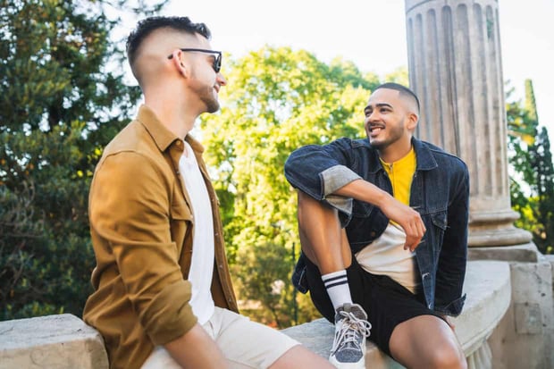Portrait of happy gay couple spending time together and having a date at the park. Lgbt and love concept.