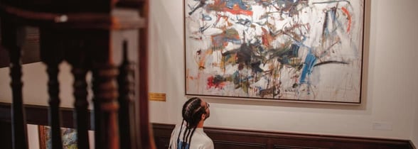 Person looking up at large painting in gallery
