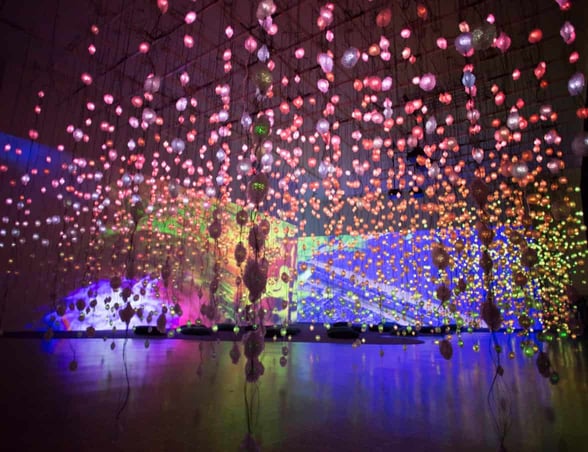 Colorful LED lights hanging from ceiling in large, dimly lit room Colorful LED lights hanging from ceiling in large, dimly lit room