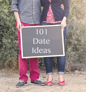 woman and man hold chalkboard that says 101 date ideas