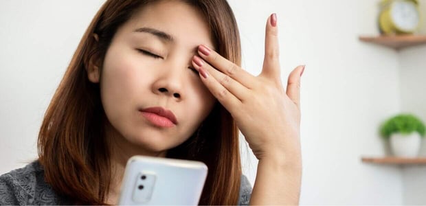 Exhausted woman holding cellphone.