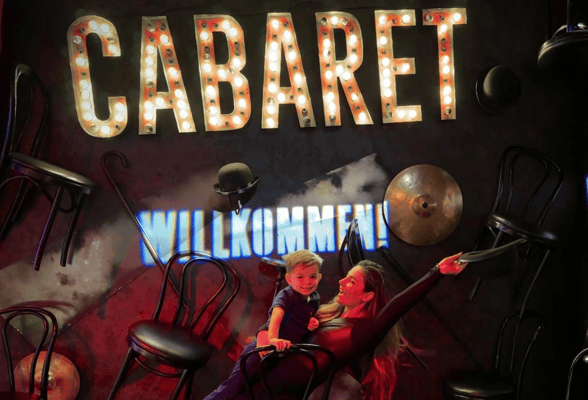 A woman and child at The Museum of Broadway's Cabaret exhibit