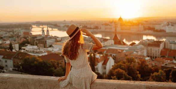 Woman facing sunset over a European city