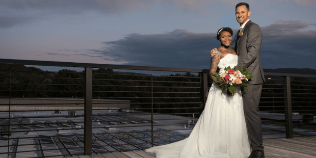 Bride and groom posing at Highland Brewing rooftop