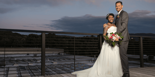 Bride and groom posing at Highland Brewing rooftop