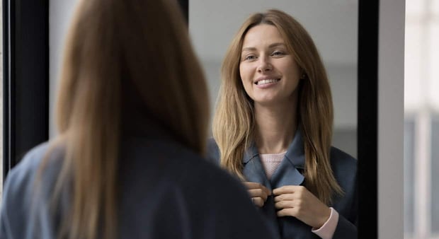 Photo of woman looking in the mirror
