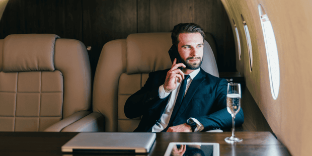 Successful businessman talking on the phone in a private jet Successful businessman talking on the phone in a private jet