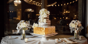 white wedding cake on table with flowers
