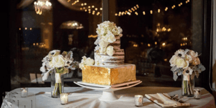 white wedding cake on table with flowers white wedding cake on table with flowers