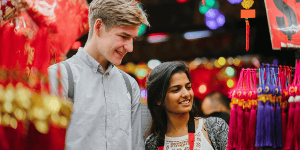 Interracial couple with Indian young woman and white young man in colorful ethnic market