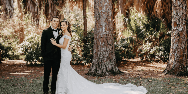 Bride and groom posing in front of trees