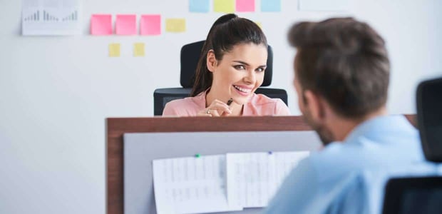 Photo of a woman smiling at a male coworker