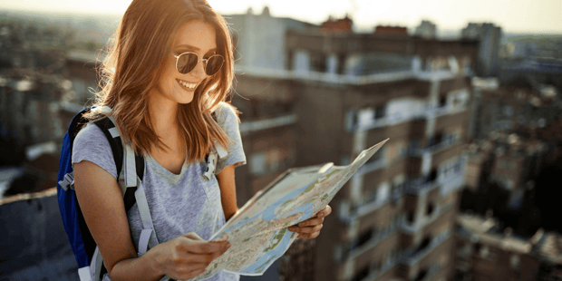 Young woman solo traveling looking at a map