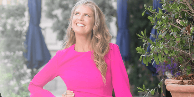 Kimmy Seltzer smiling up at the sky in a bright pink dress