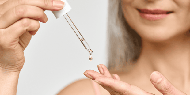 Senior woman using dropper of hyaluronic acid Senior woman using dropper of hyaluronic acid