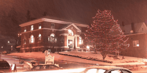 Littleton, New Hampshire library with lit Christmas trees