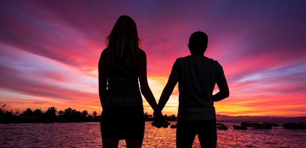 tall woman holding hands with a man