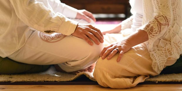 couple sitting on ground facing each other