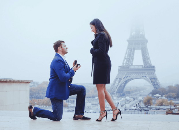 A couple getting engaged in front of the Eiffel Tower in Paris, France