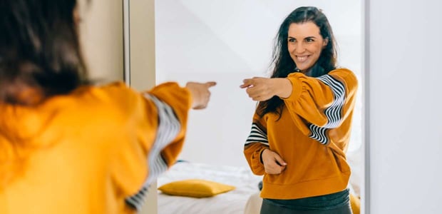 Photo of a woman pointing at herself