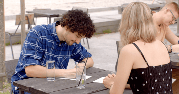 Young man and woman taking notes on speed dating event Young man and woman taking notes on speed dating event