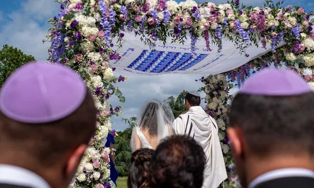 Couple getting married under chuppah