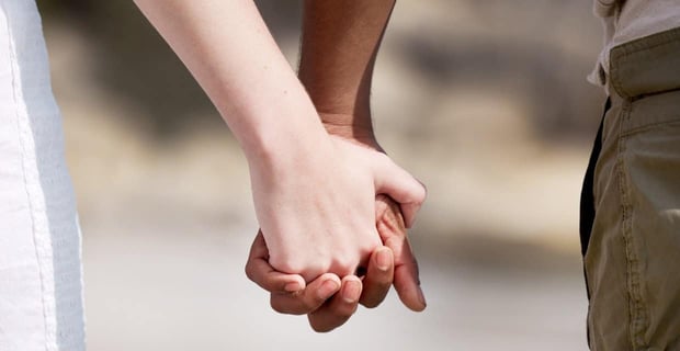 Holding hands interracial couple shutterstock