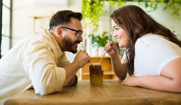 Happy couple on date sharing root beer float Happy couple on date sharing root beer float
