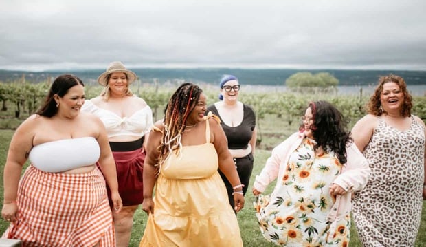 Beautiful curvy women laughing near beach