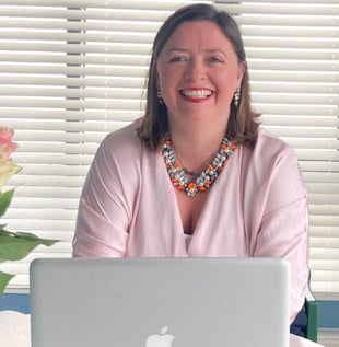 Eimar using laptop and smiling photo by Albane McGuinness @AlbaneBrandPhotography