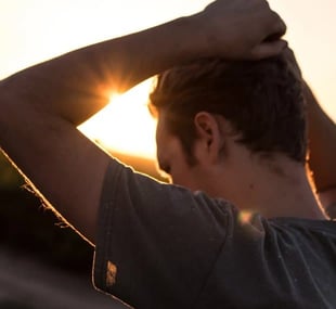 Man holding his hands above his head in thought