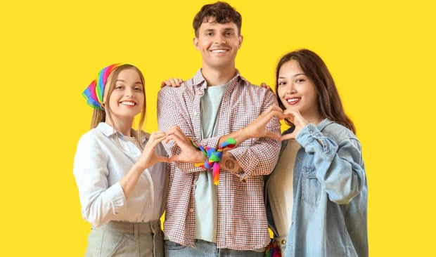 Photo of a man and two women making hearts with their hands
