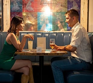 Photo of a young male and female couple sitting in a restaurant on a speed date