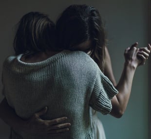 Photo of two women couple hugging and dancing together looking sad and dancing in a dark shadowy room