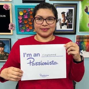 Young woman holding a sign that says I'm an empowered Passionista