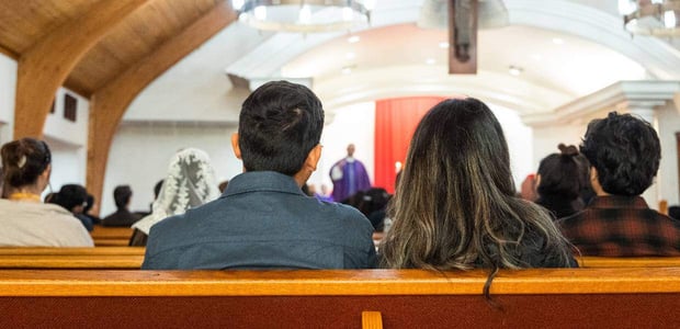 Couple in sitting church pews during a sermon
