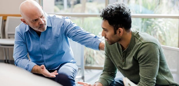 Therapist placing hand on man's shoulder