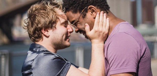 Two men holding one another affectionately. Two men holding one another affectionately.