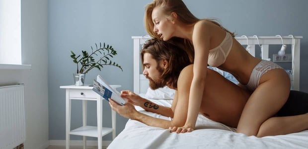 Couple in bed, both reading a book.