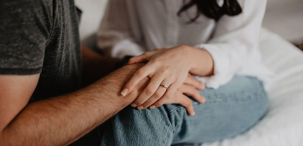 Close up of couple holding hands.