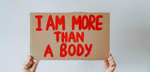 Sign reading "I am more than a body".
