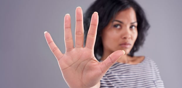 Woman with outstretched hand toward camera, gesturing "stop", "no", or "talk to the hand".