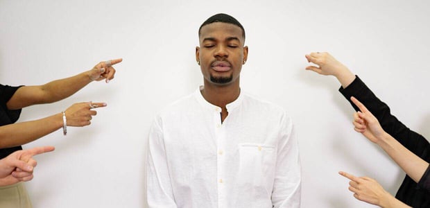 Multiple pointing at man, who is standing there with his eyes closed