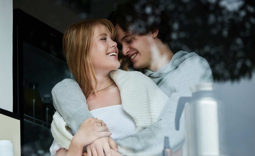 Young couple hugging and laughing together in the kitchen 
