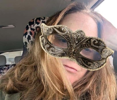Woman wearing a costume mask in a car