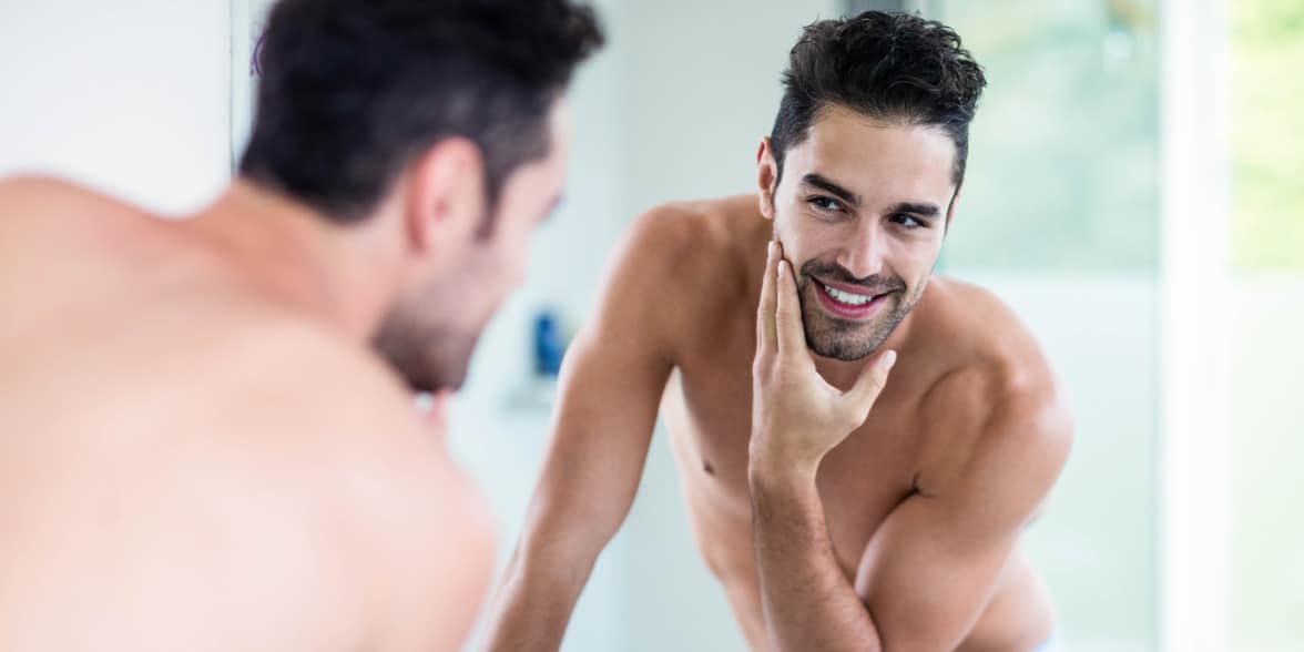 Photo of a man looking at himself in the mirror